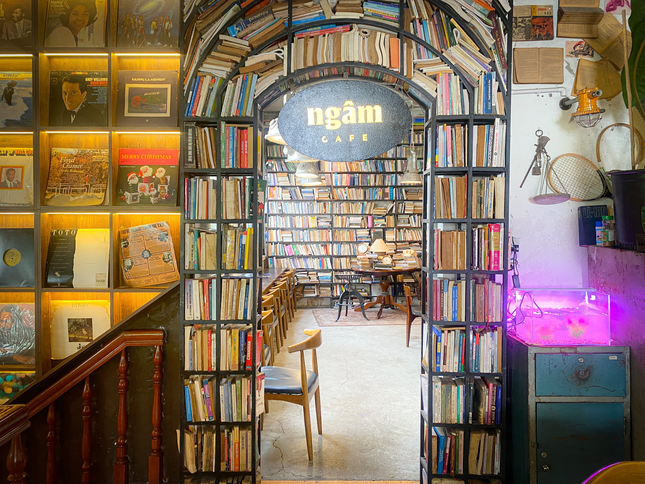금빛 ngâm CAFE 글자가 새겨진 검은 타원형 간판 근접 촬영