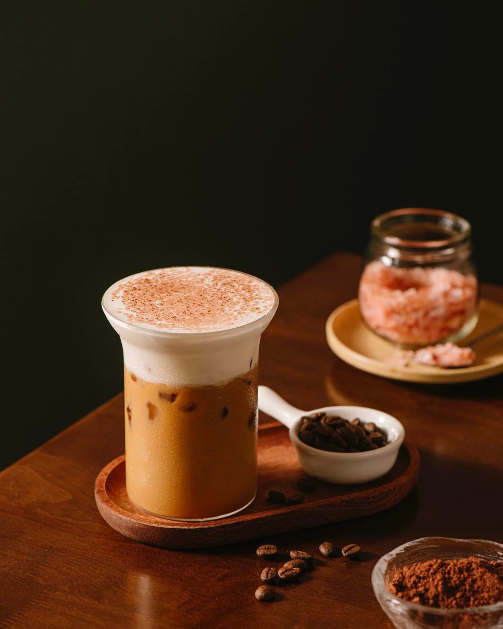 Ly latte đá rắc cacao trên khay gỗ