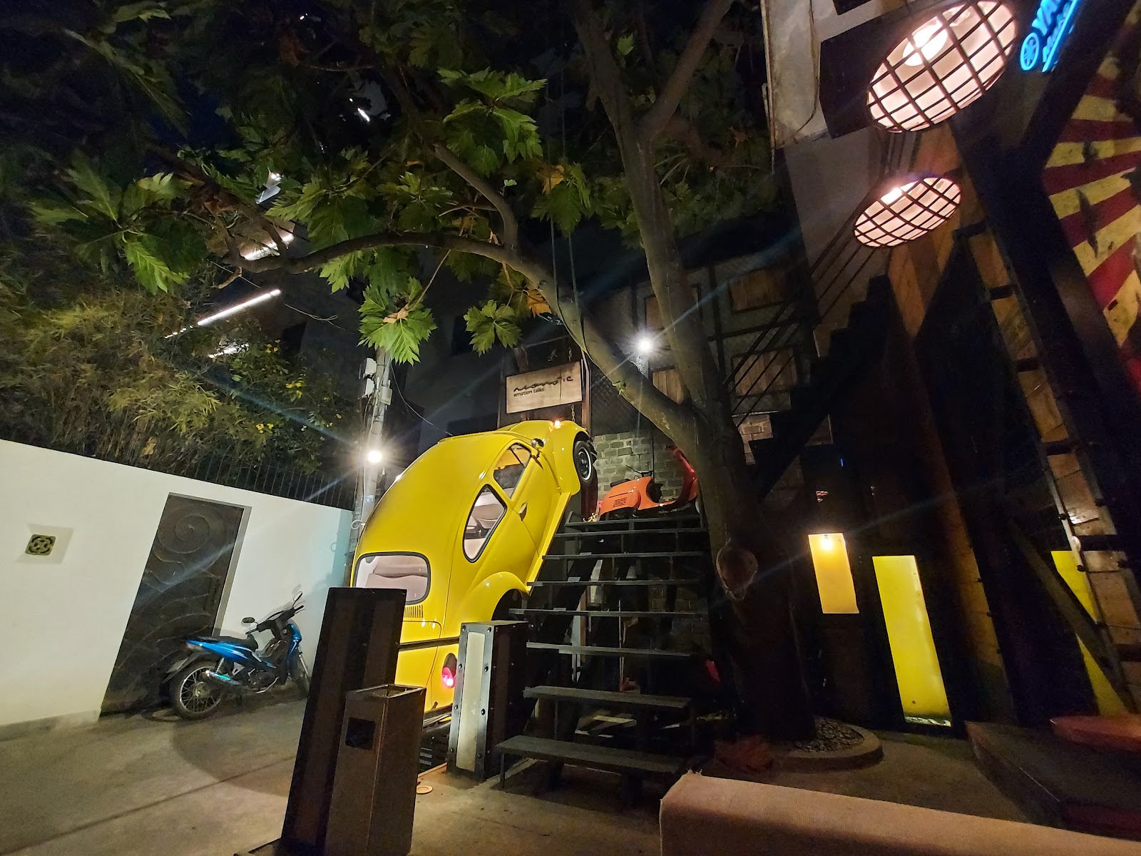 Acoustic Bar's entrance at night with the yellow Beetle on the wall