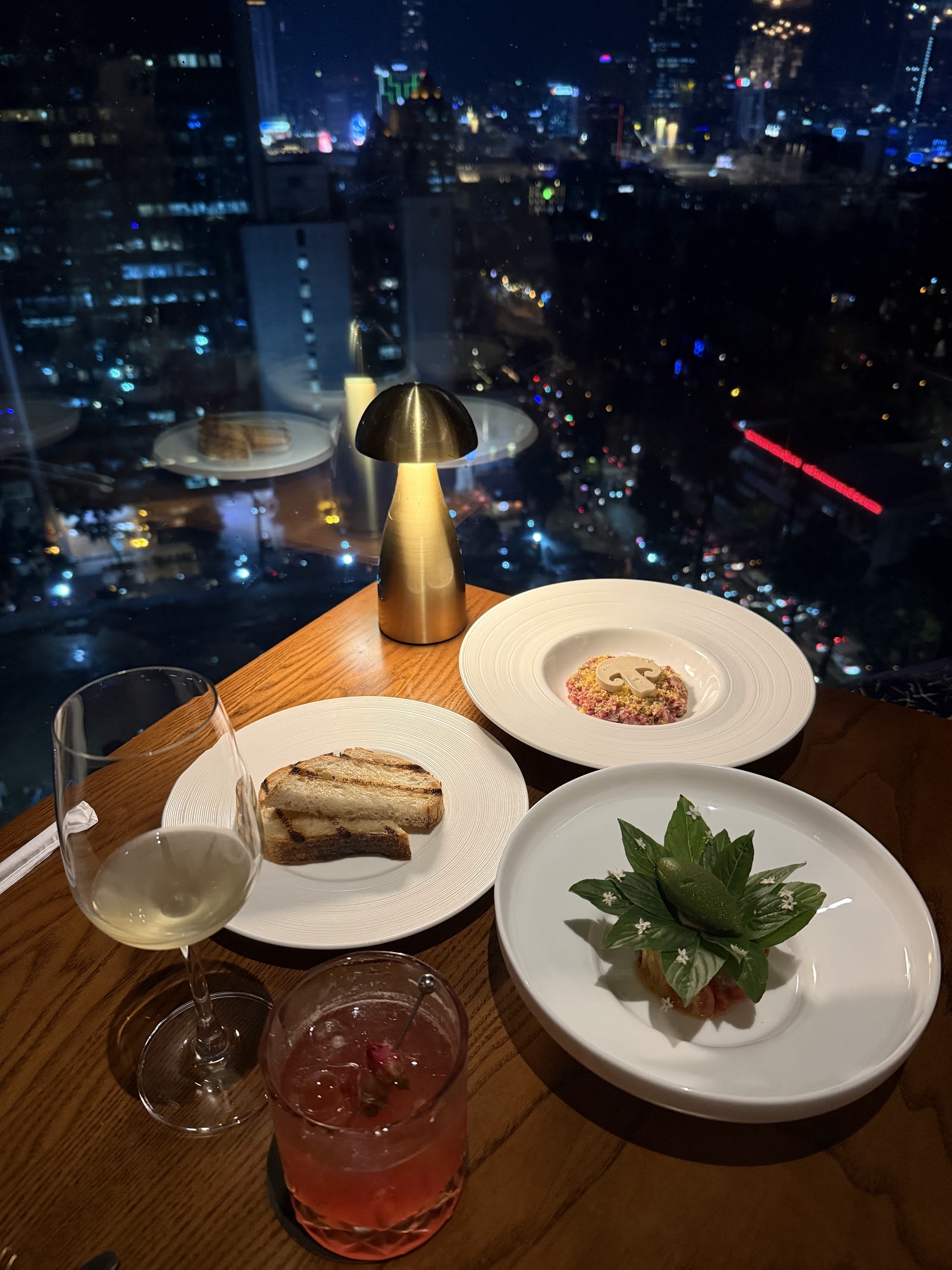 A window table above the city lights at night