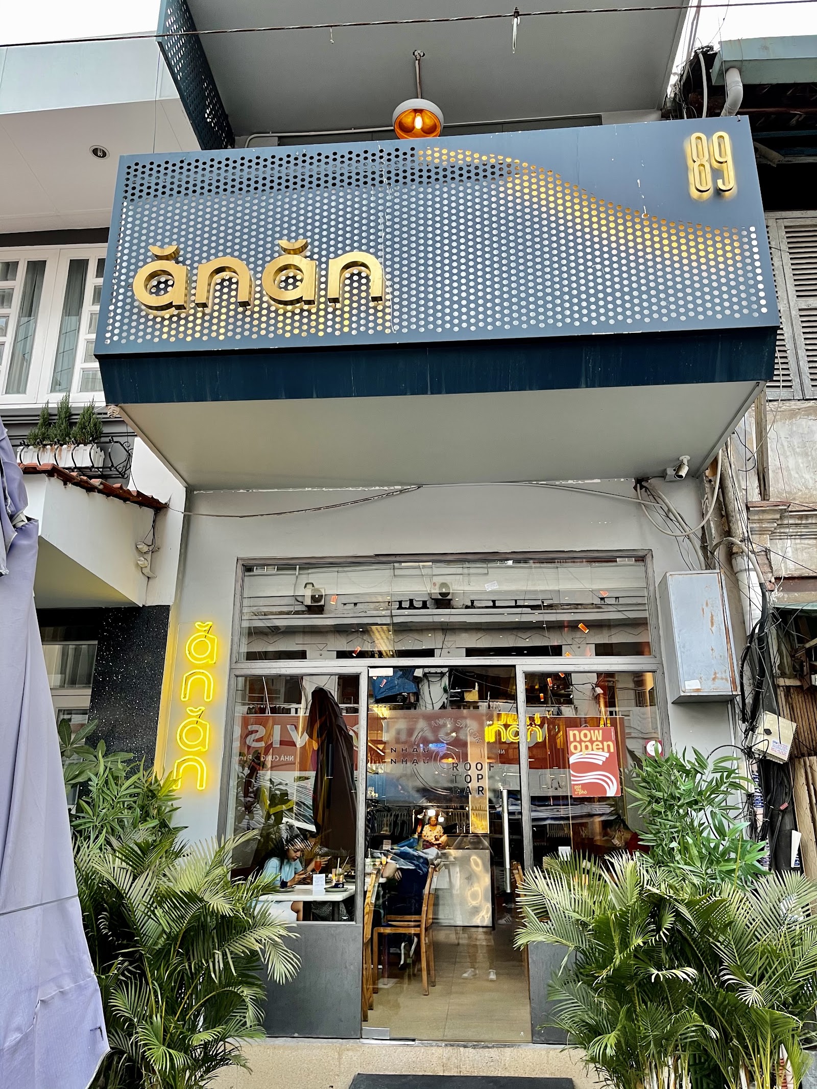 The gold ăn ăn sign and number 89 on the 89 Ton That Dam storefront