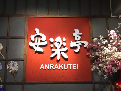 The red wall carrying the white 安楽亭 characters inside Anrakutei