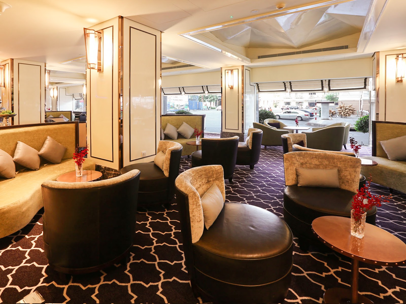 Café de l'Opéra 라운지: 크림·골드 패널 기둥, 다크 우드 암체어와 소파, 람선 광장으로 난 창