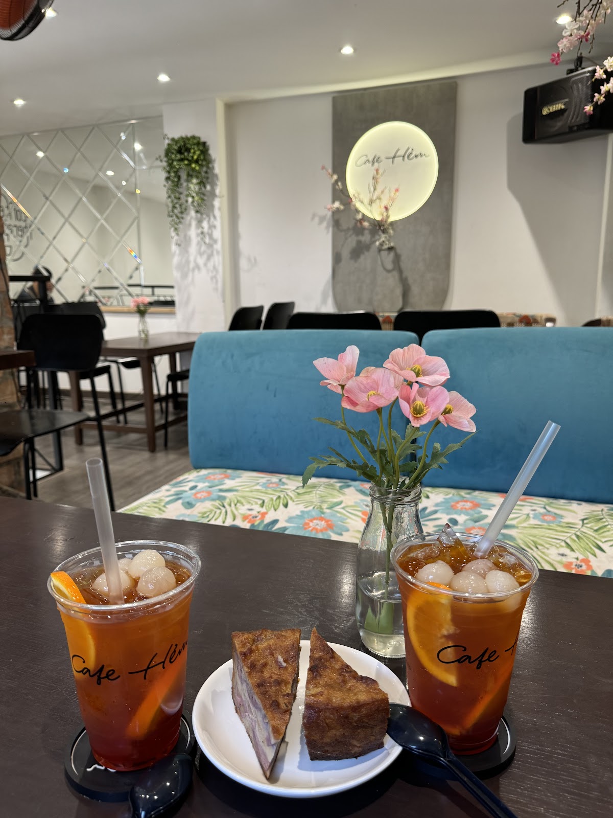 벤치 좌석 옆 테이블 위 아이스티 두 잔과 케이크