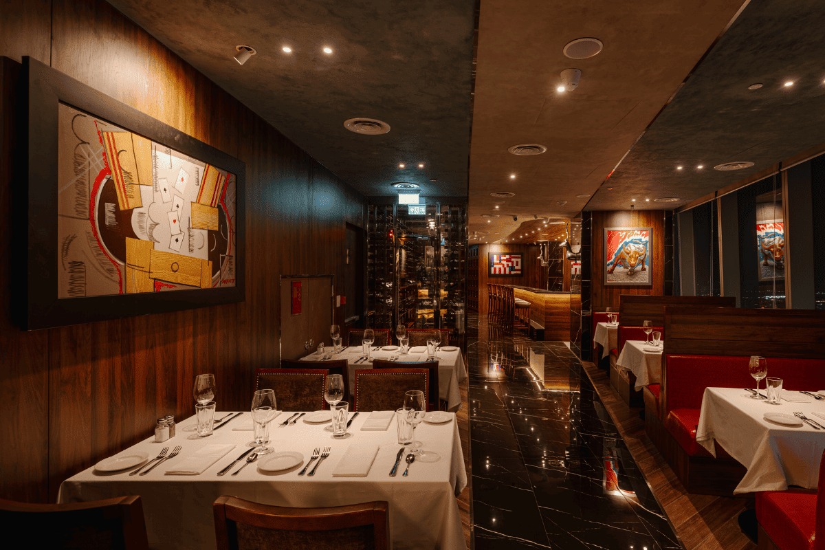 Phòng ăn ốp gỗ sẫm với ghế bọc da đỏ của The Capital Grille