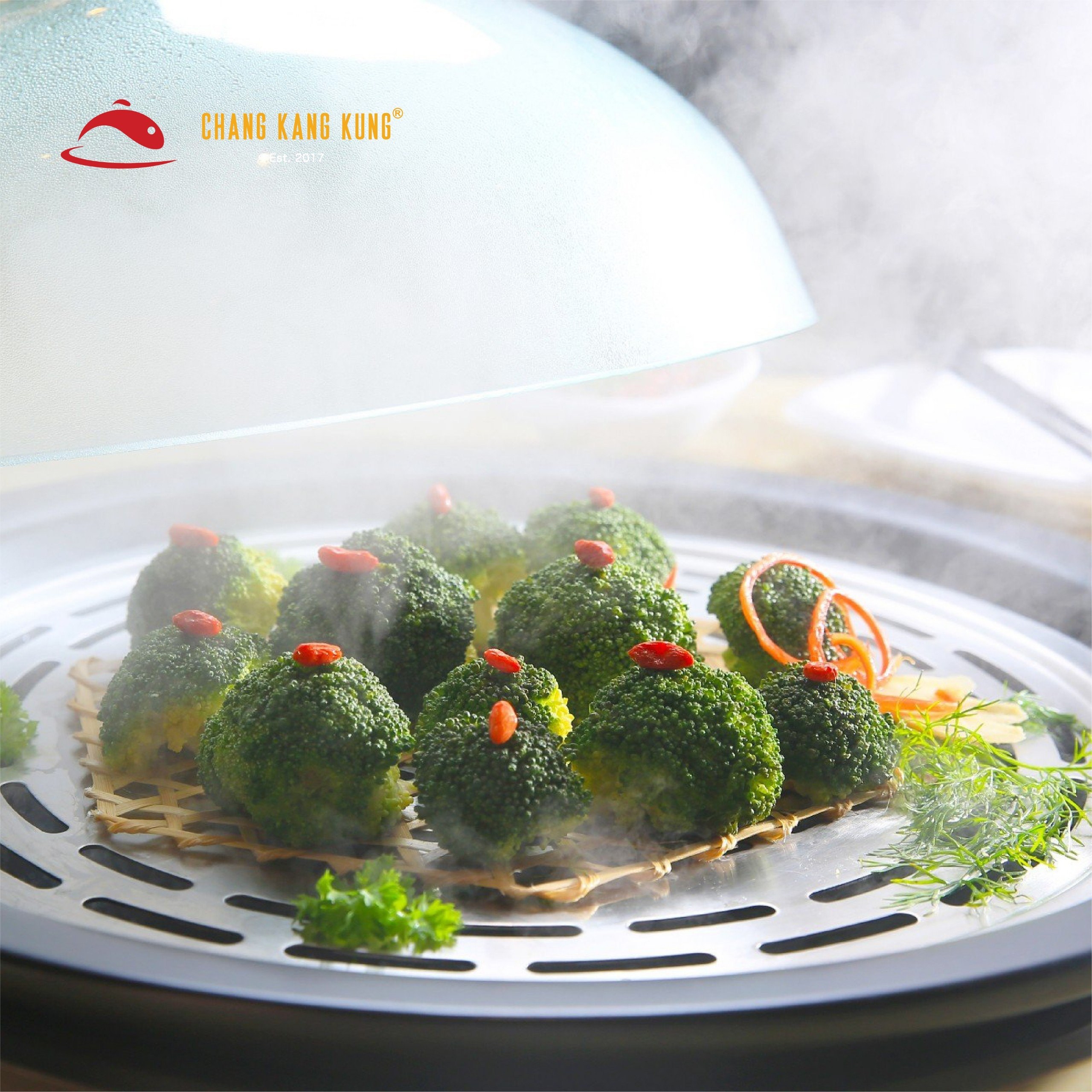 Nắp vung thủy tinh mở ra, hơi nóng bốc lên trên vỉ hấp