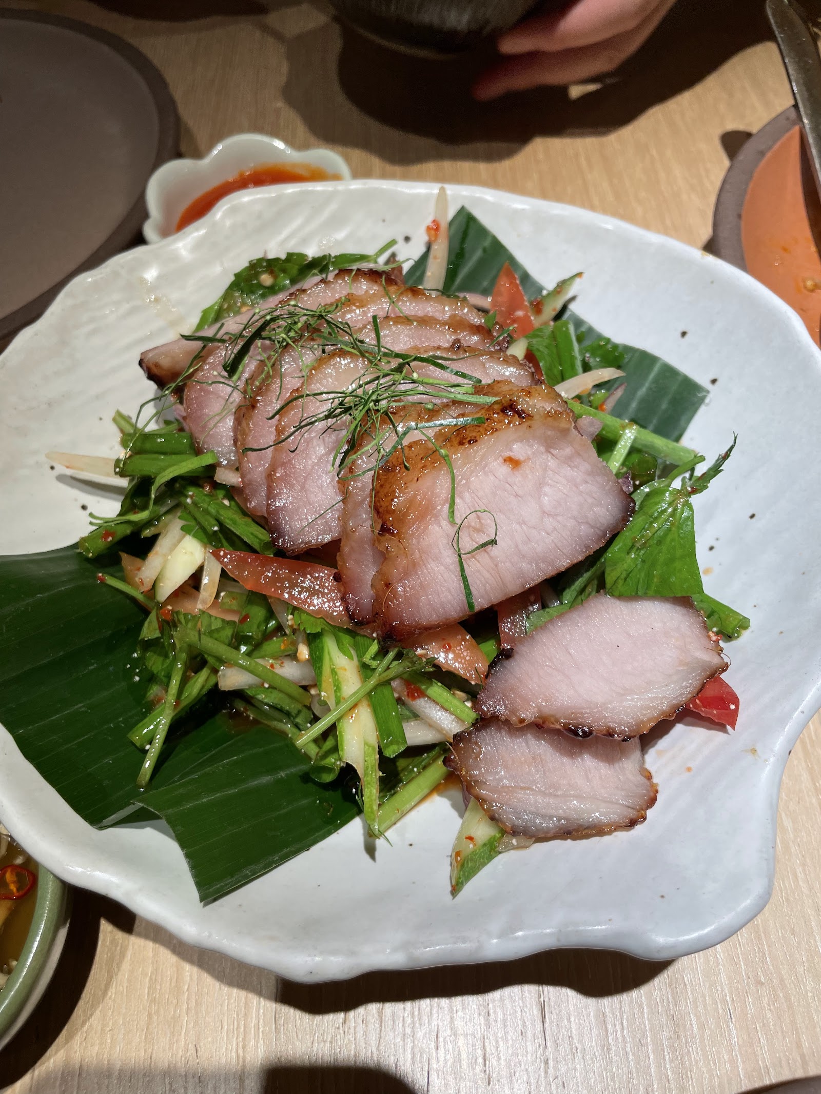 Thịt heo nướng thái lát trên rau thơm tươi