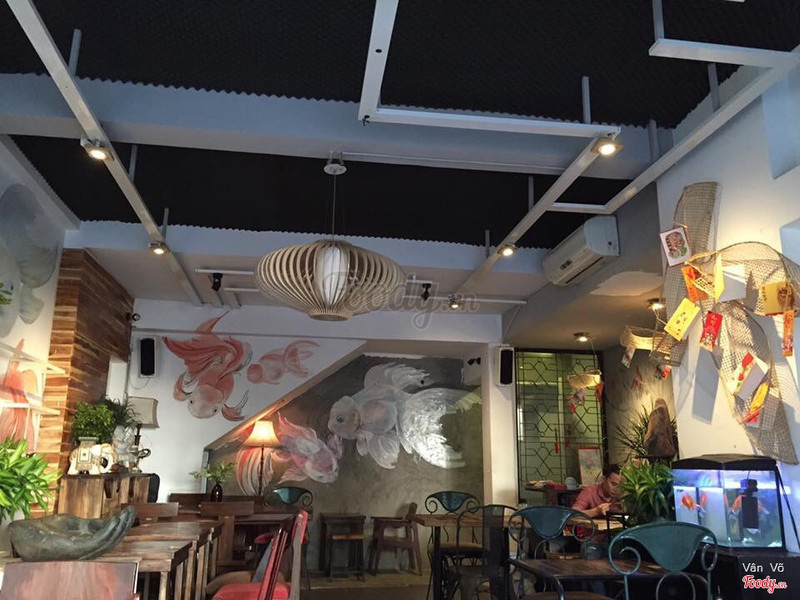 The koi-painted wall, rattan pendant lamp, and fish tank inside the shop