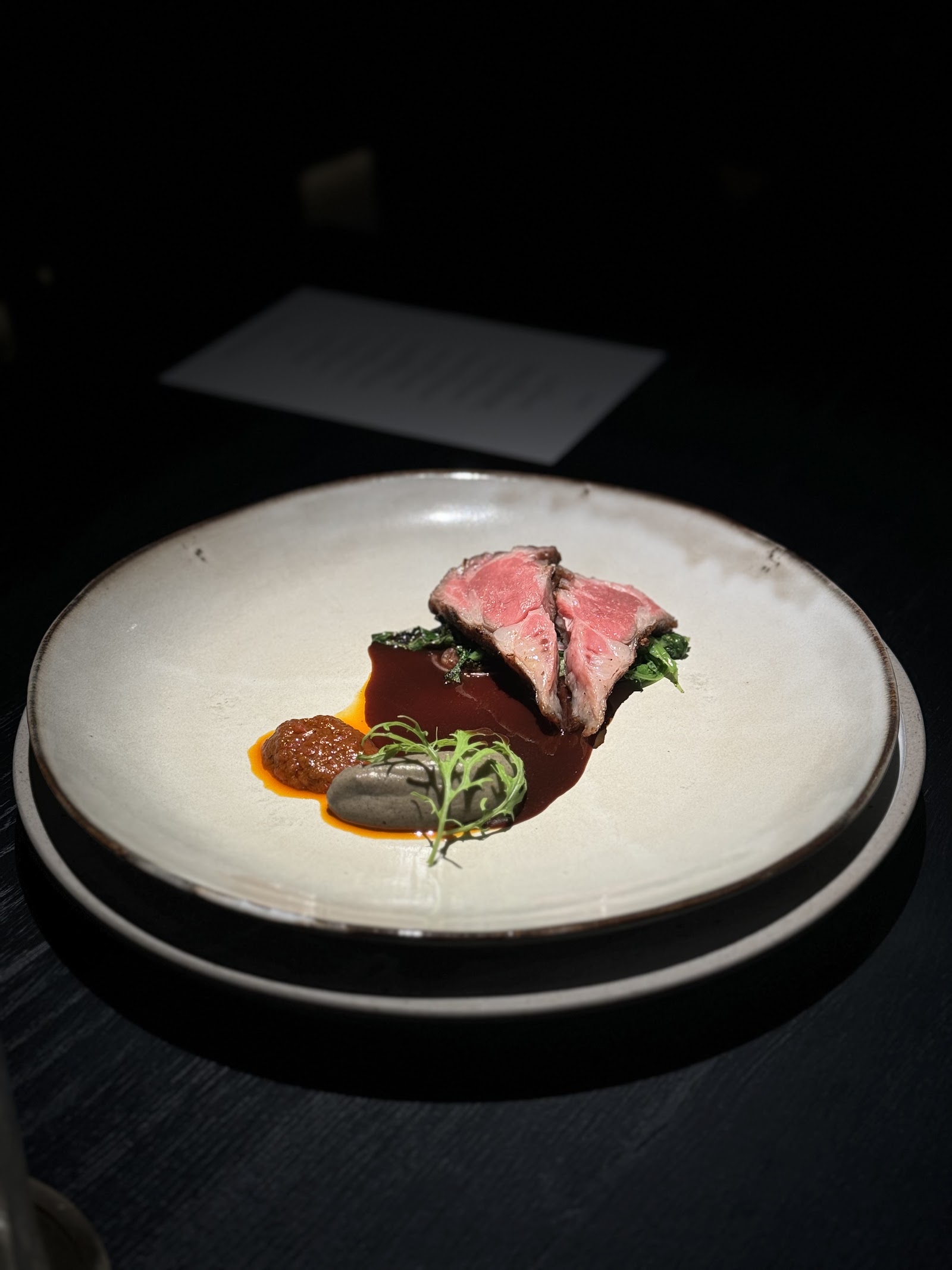 Plated blushing seared beef with dark glossy sauce
