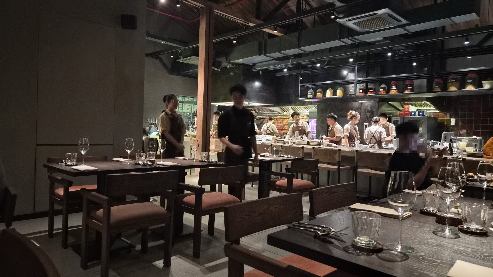 The dining room with tables and the kitchen crew behind