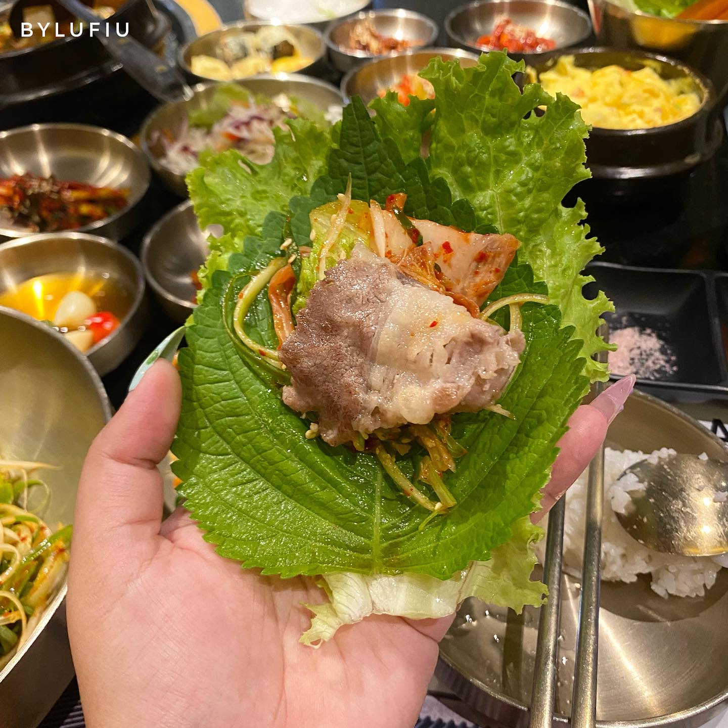 Cuộn ssam cầm tay — thịt nướng, kim chi và banchan
