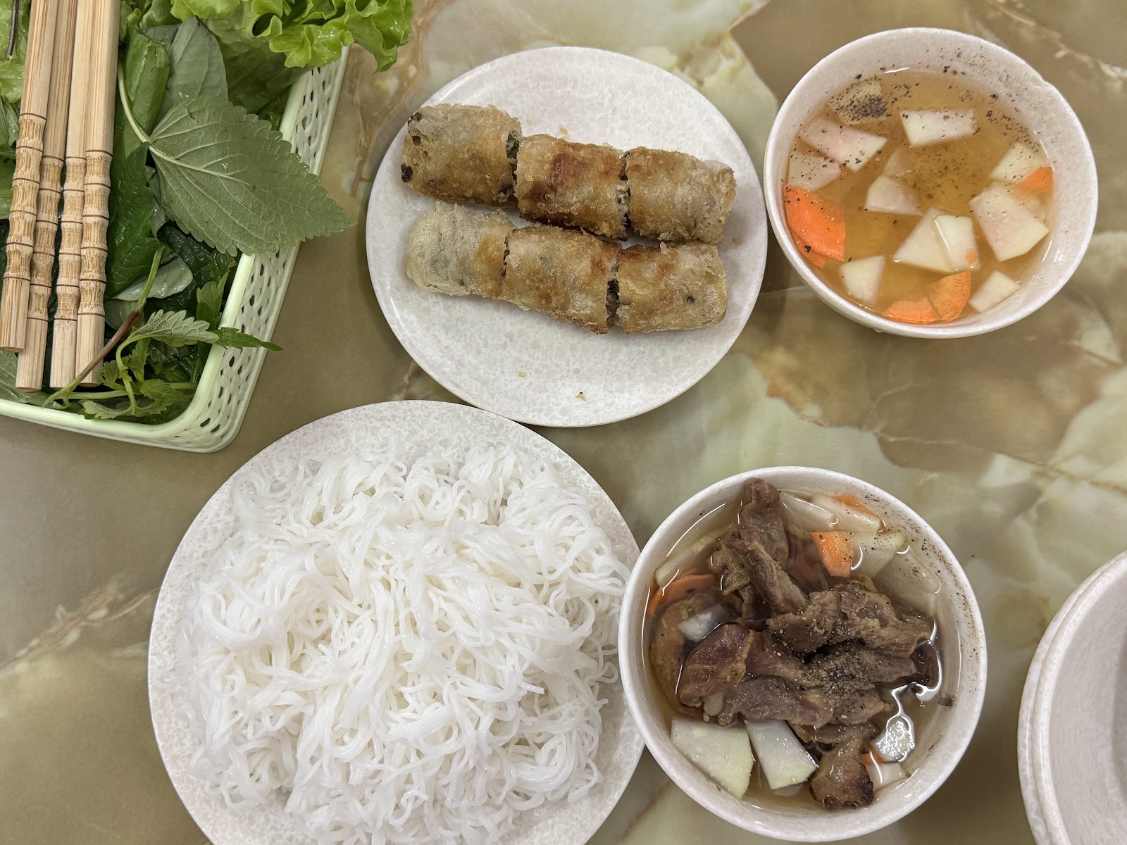 Nem cua biển — dĩa nem rán giòn ăn cùng bún trắng, rau sống, dưa góp và bát thịt nướng