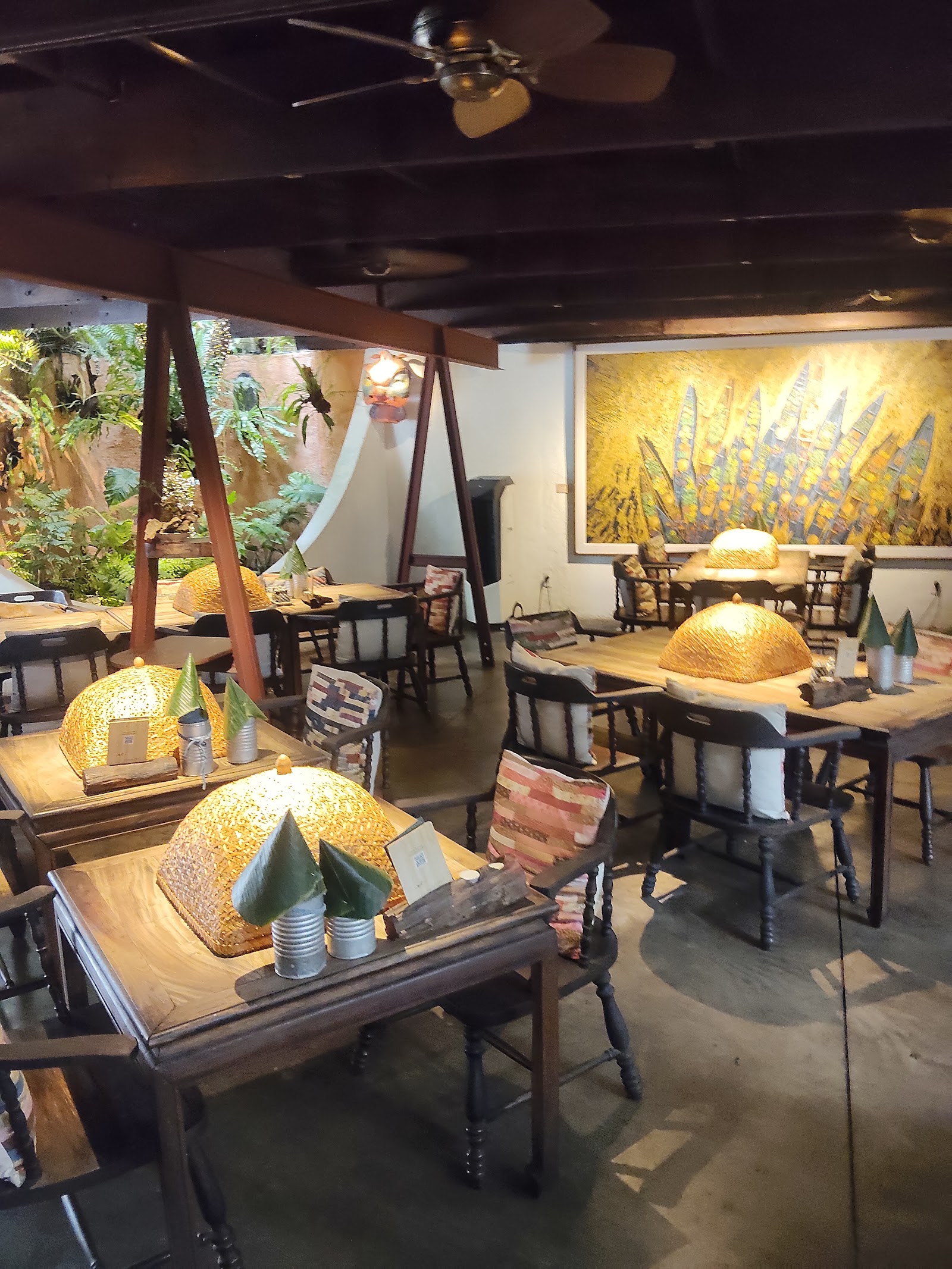 The dining room with rattan food covers on the wooden tables