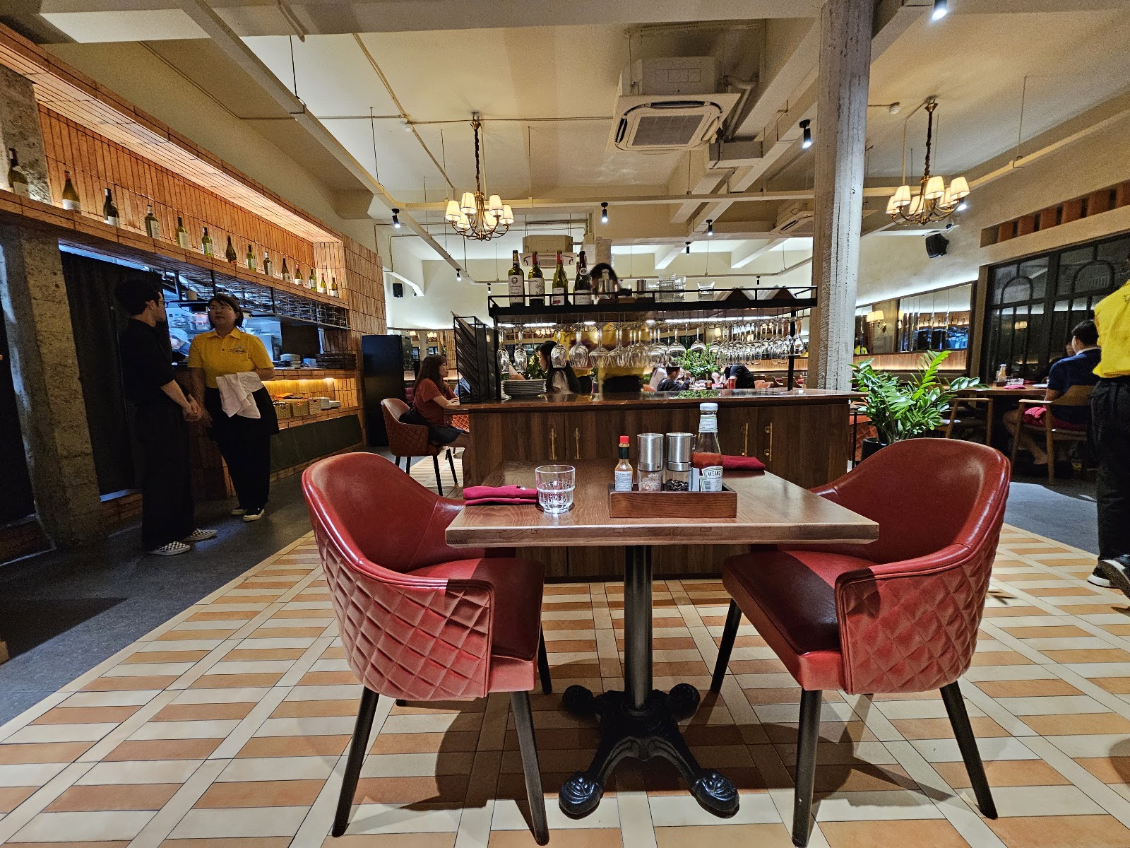 The dining room with quilted red-leather chairs, the bar and chandeliers