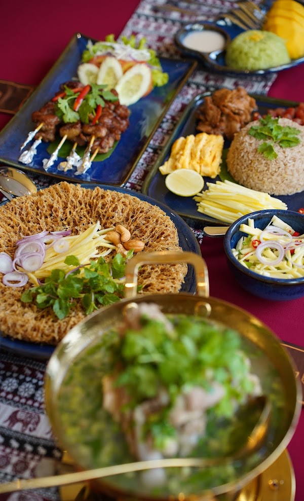 Mâm món Thái — nồi đồng, gỏi xoài, chén chấm — ảnh của chủ quán