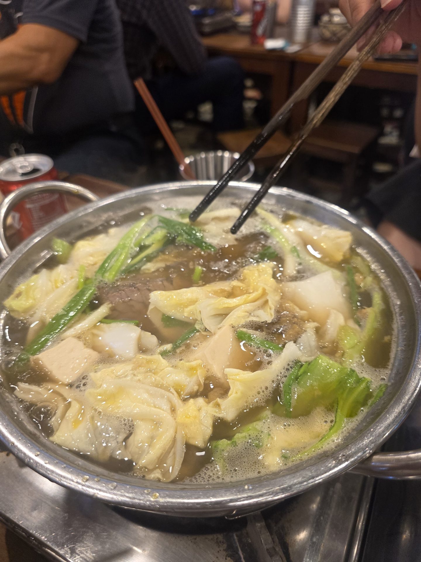 Giữa bữa ăn tại Lẩu Bò Nhà Gỗ — nồi lẩu vẫn sôi