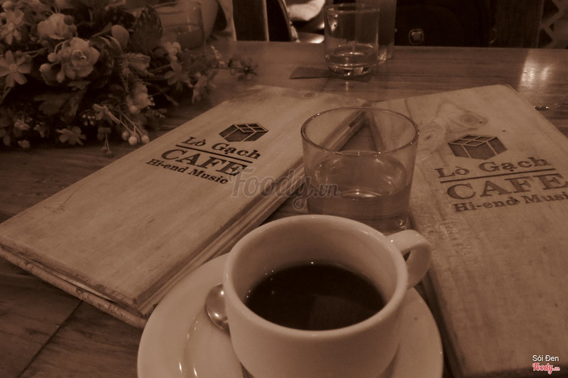 The venue's wooden menu boards and a black coffee