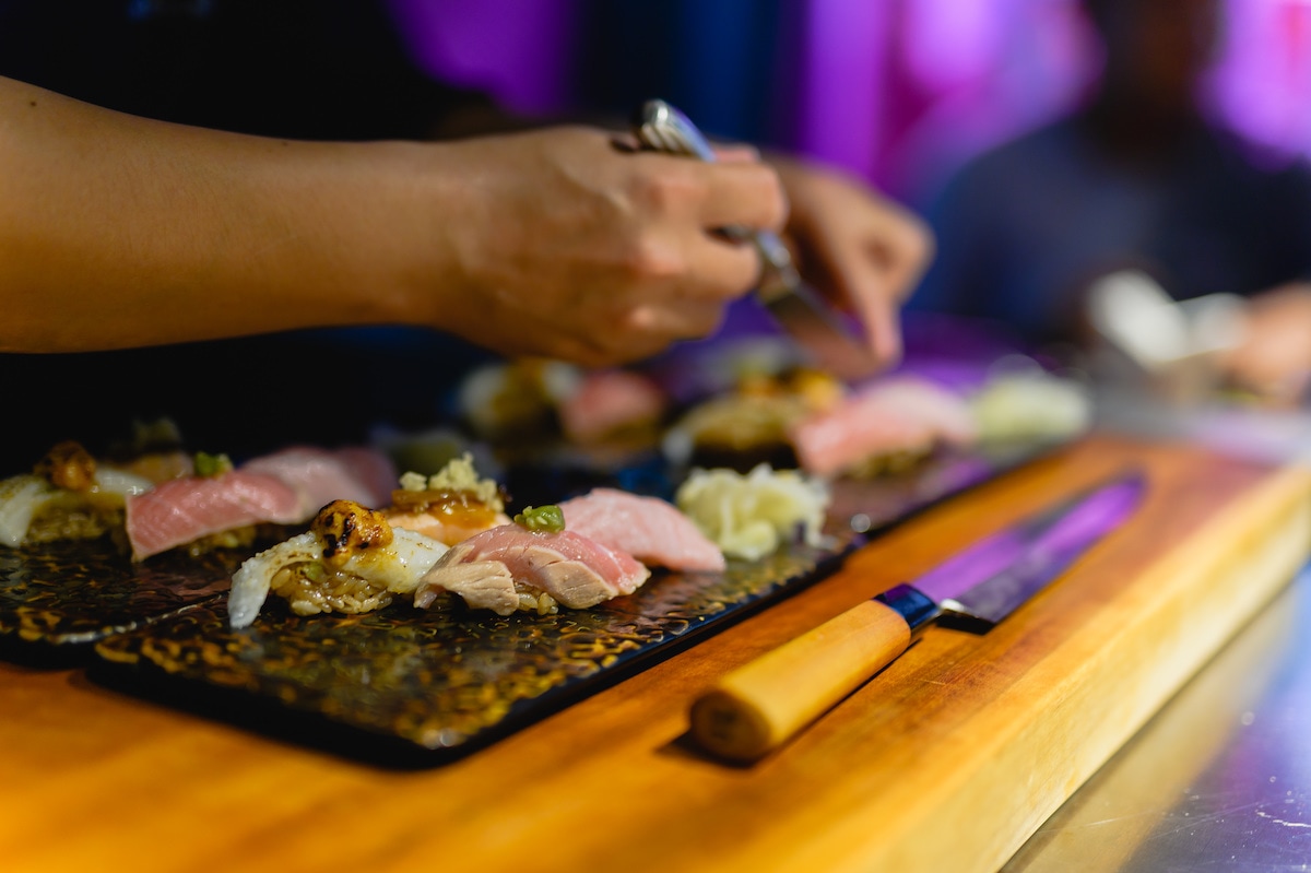 The itamae breaking down fish at the MAGURO Studio wooden counter