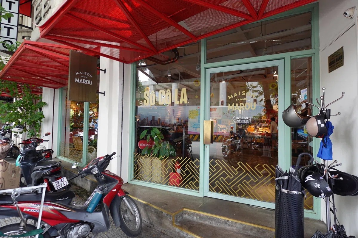 Maison Marou Flagship Saigon — red awning, mint-green frames, gold SÔ CÔ LA lettering