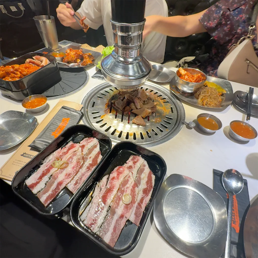 고기 쟁반과 반찬이 가득한 흰 에나멜 테이블