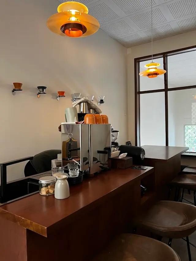 Mew Roastery SG — 세이지 색 베이스 위 월넛 카운터의 아일랜드 바