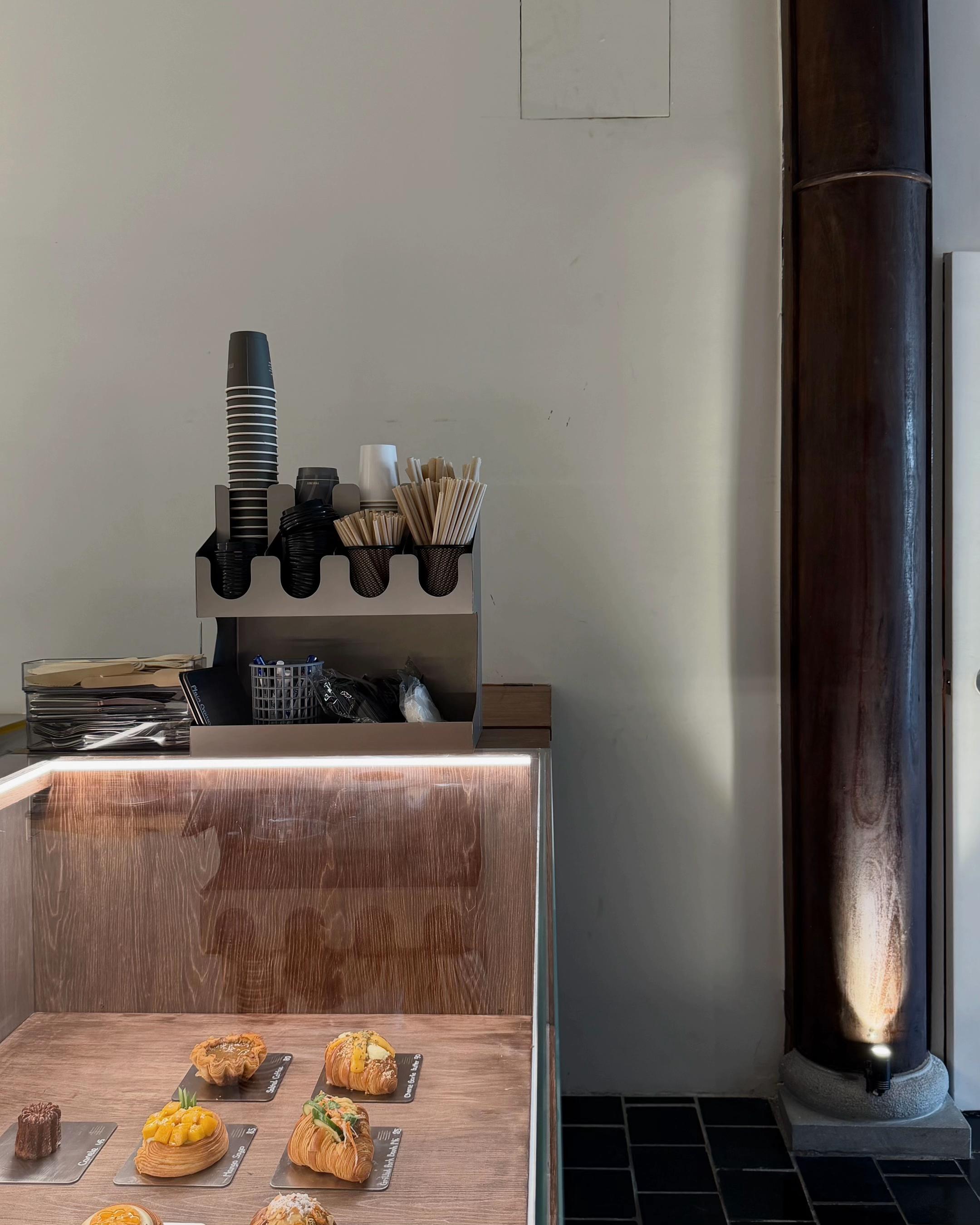 Mille Mille Ben Thanh — the pastry case: croissants on slate boards under lit glass