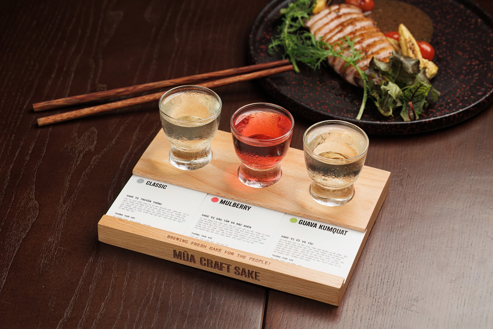 Flight sake trên khay gỗ khắc tên quán, kèm thẻ nếm