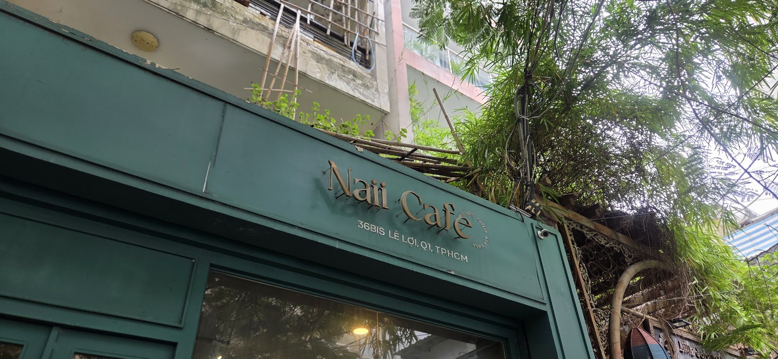 Gold 3D Naii Cafe script on the teal wall