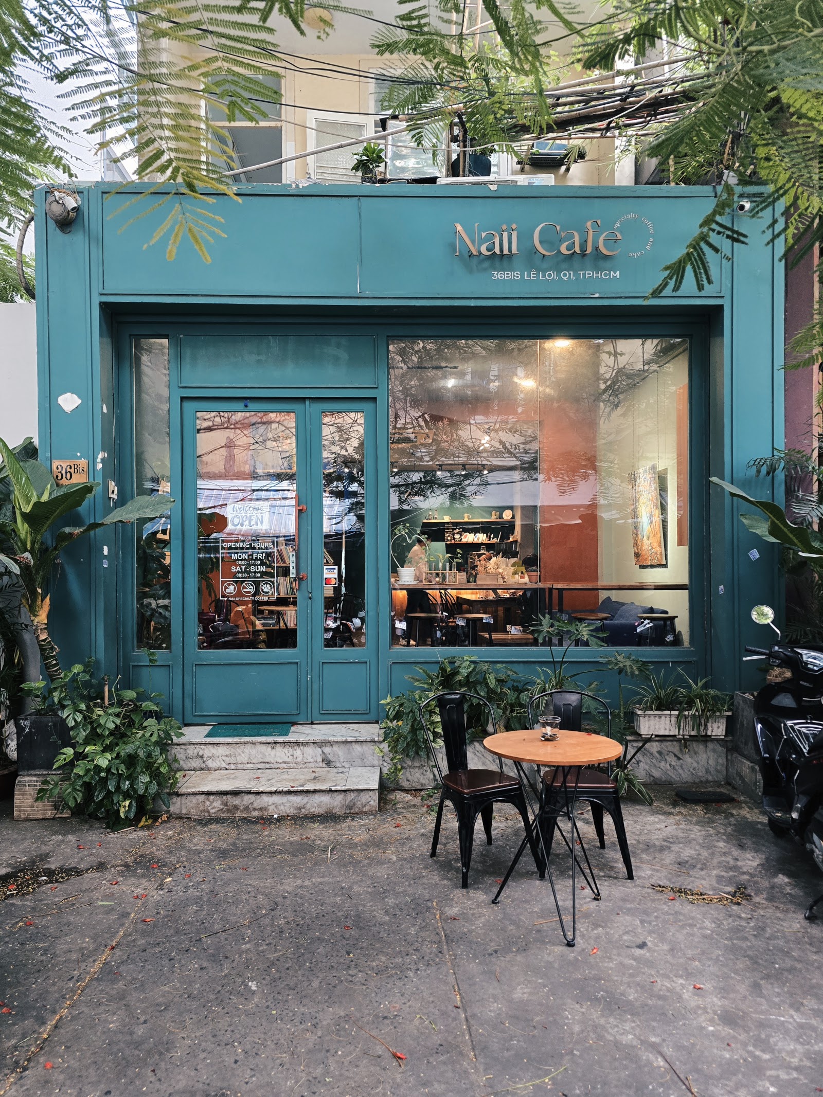 Teal storefront with gold Naii Cafe script in alley 36