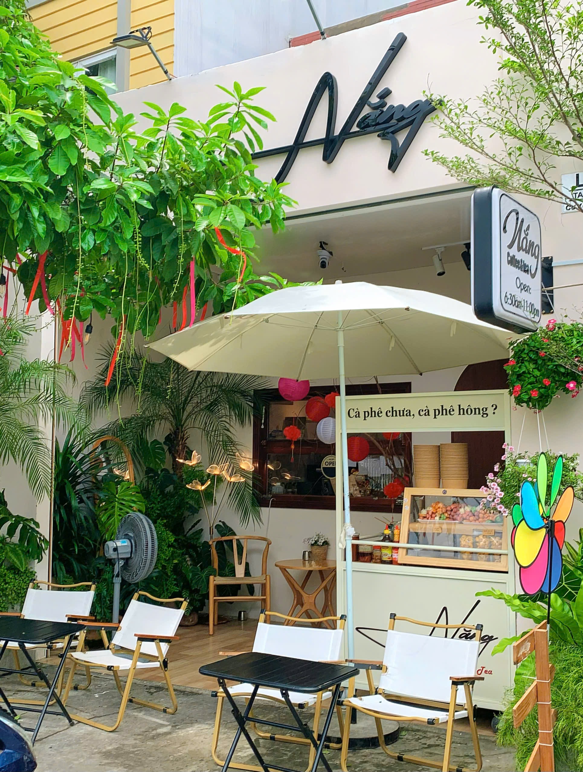 낮의 Nắng Cafe 외관, Nắng 간판과 야외 좌석
