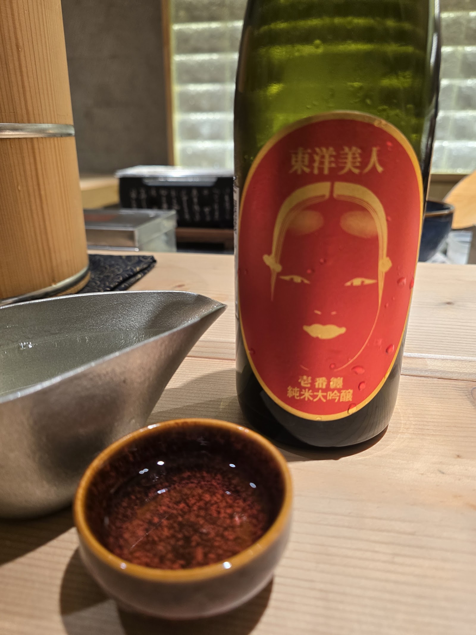 카운터 위의 토요 비진 준마이 다이긴조 — 주석 주전자, 작은 잔, 촛불