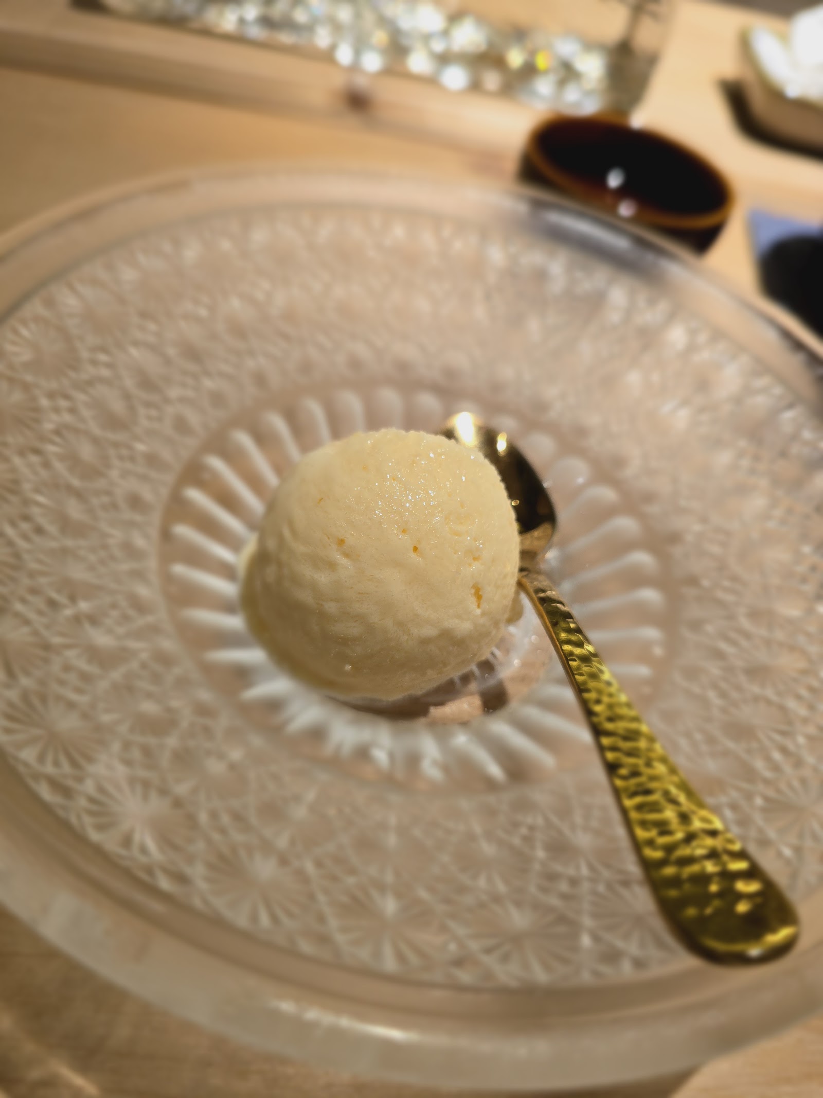 The quiet closing — yuzu sorbet on the venue's cut-glass plate