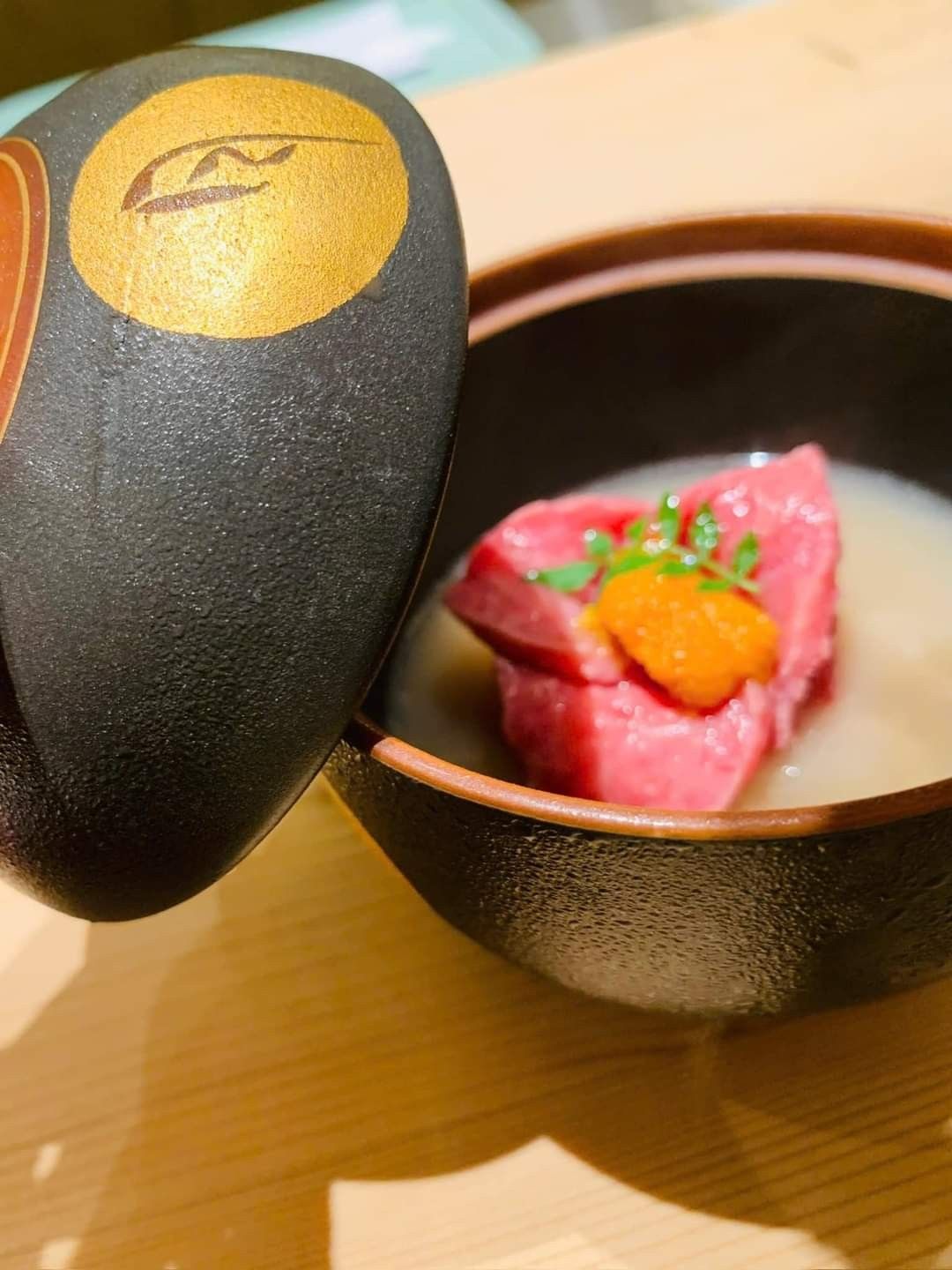 Miếng wagyu với nhum biển và trứng cá hồi trong bát đen có nắp tại Omakase Niku by K