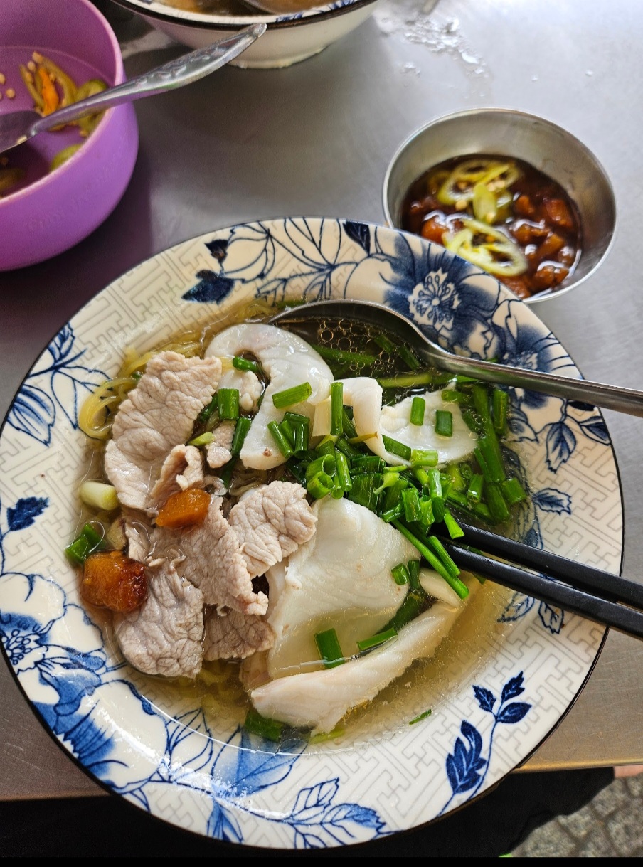 Close-up of a steaming fish noodle bowl