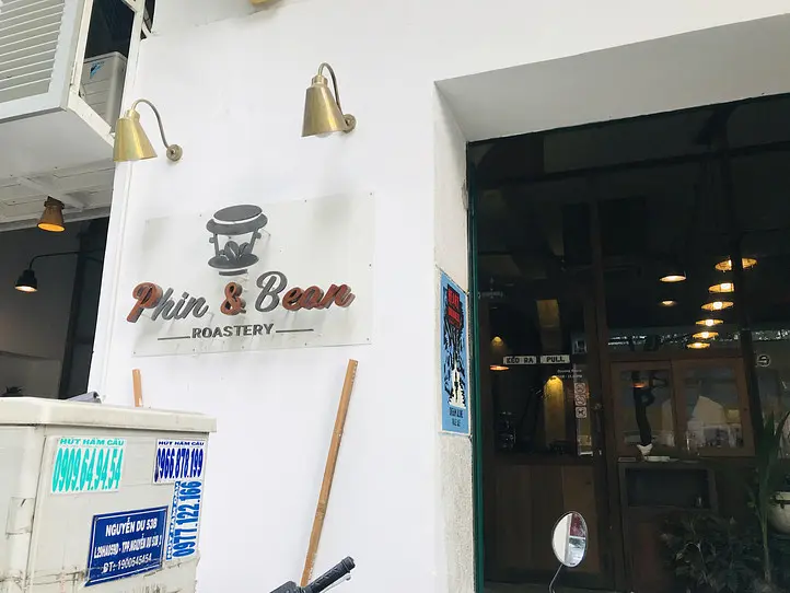 로고 간판과 황동 벽등이 있는 입구