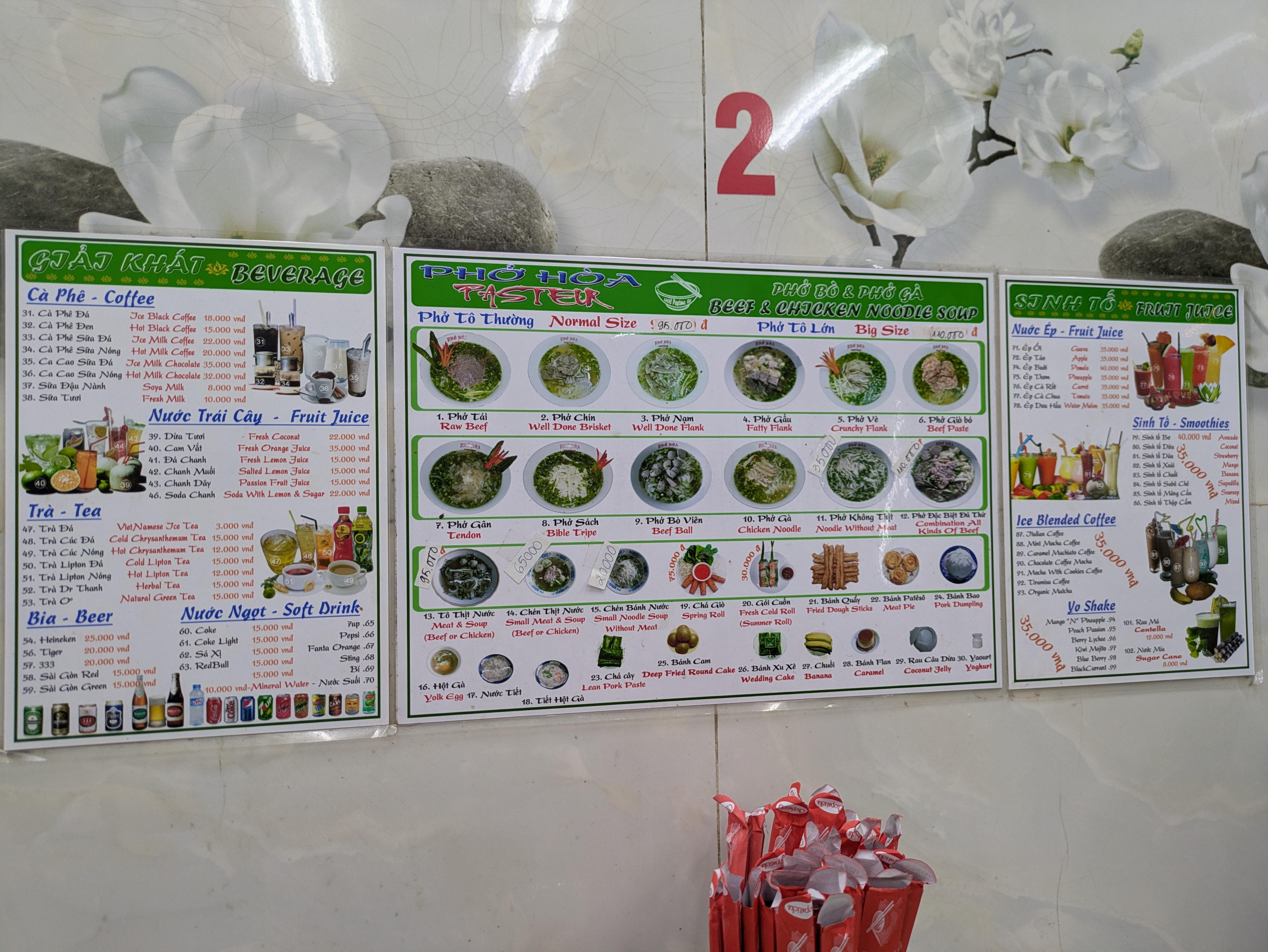 The wall menu boards inside Pho Hoa — green frames, numbered