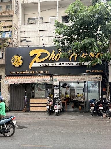 The Phở Hùng storefront: black signboard, gold letters