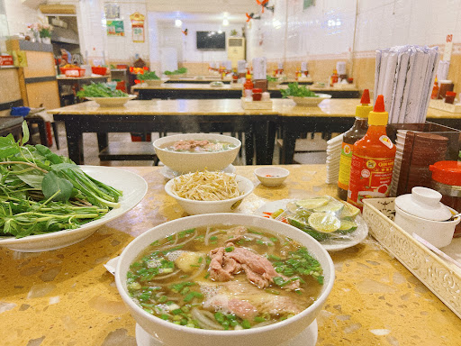 A table full of giant Phở Hùng bowls