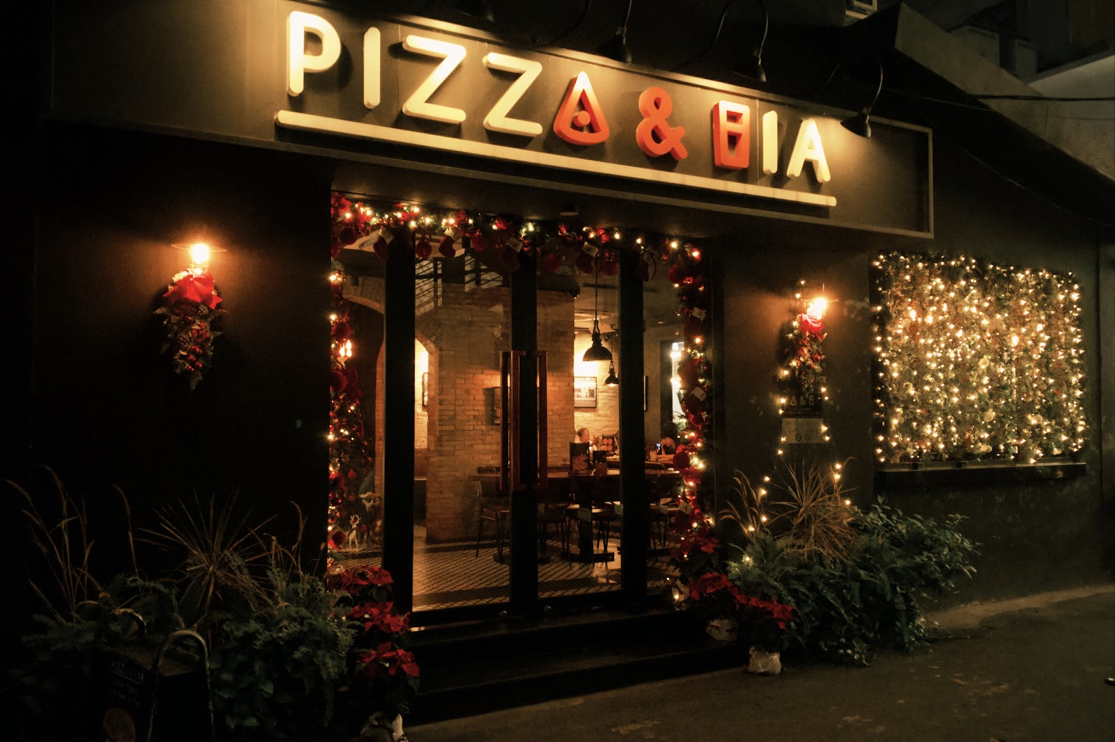 밤의 Pizza & Bia 외관 — 빛나는 간판