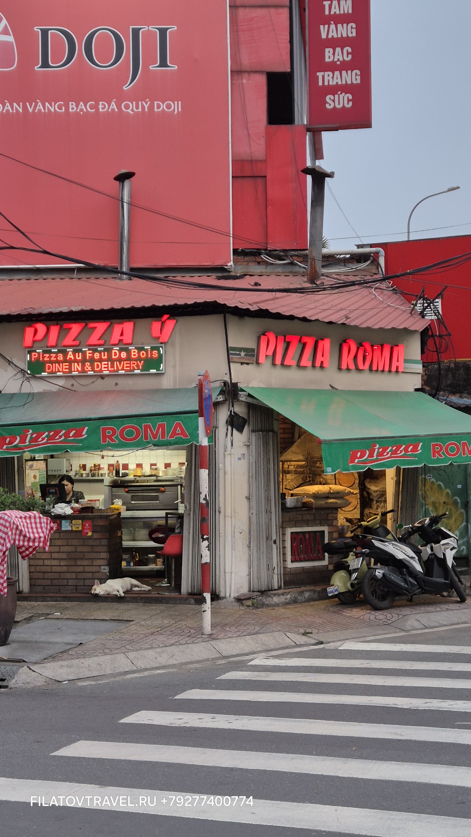 The Pizza ROMA corner storefront with its neon sign