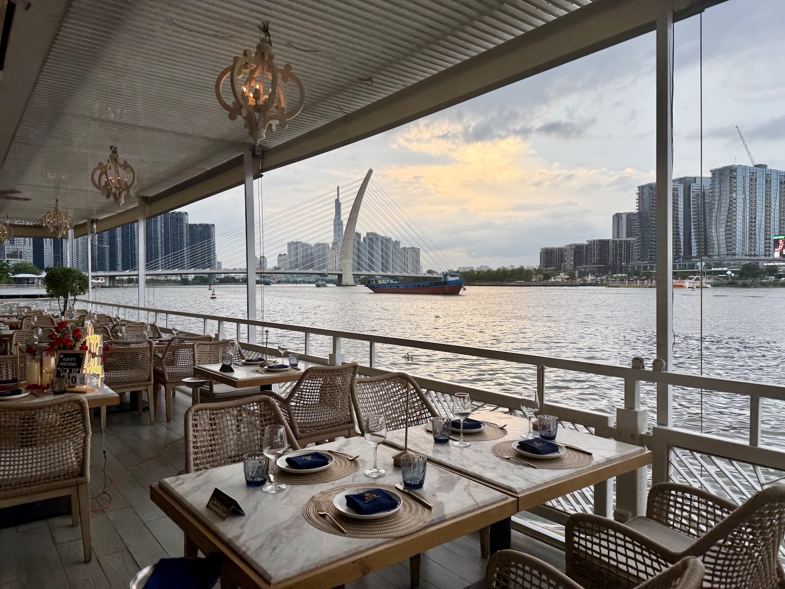 The riverside terrace at sunset, looking toward the Thủ Thiêm bridge