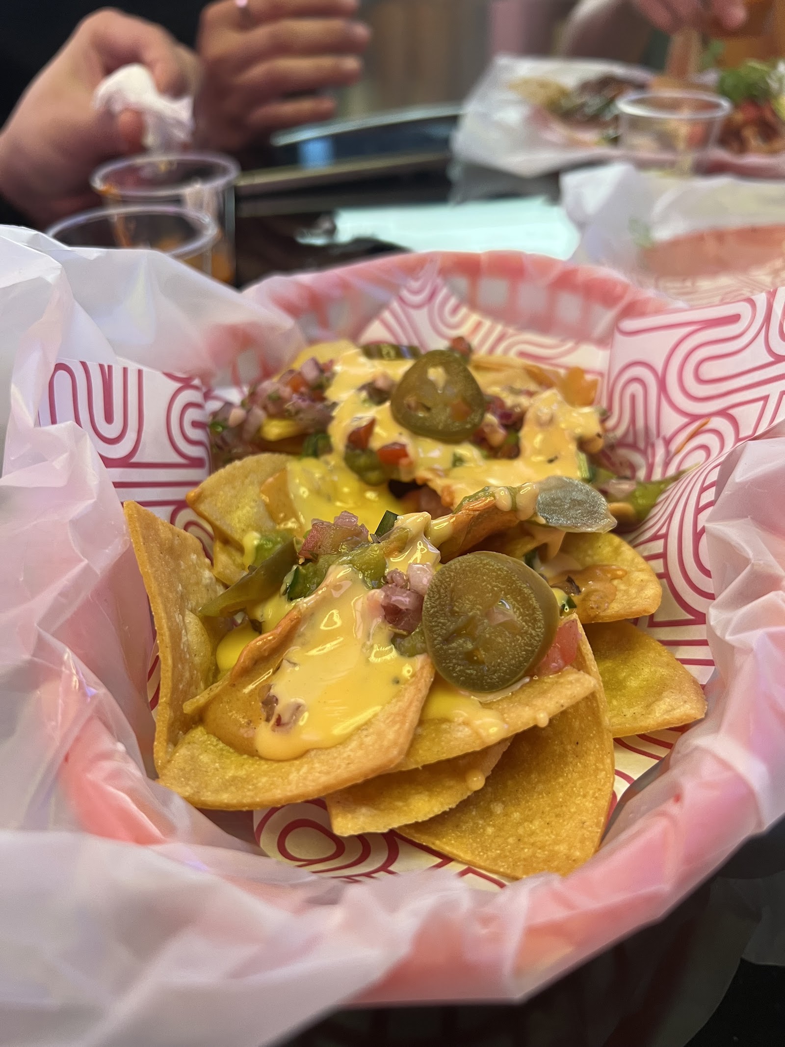 Cận cảnh nachos đầy ắp — phô mai, jalapeño, pico de gallo