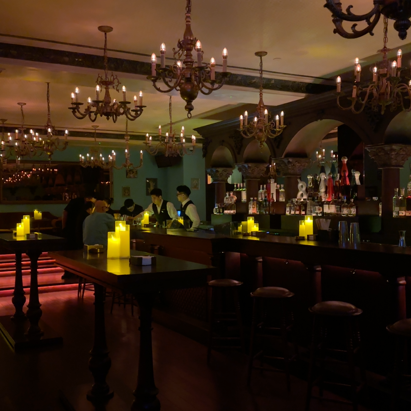 Không gian cantina — đèn chùm, quầy bar vòm, ánh nến