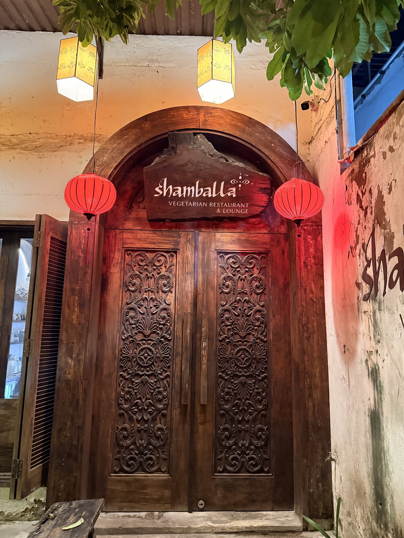 Shamballa's entrance at night — red lanterns hung at the wooden doors