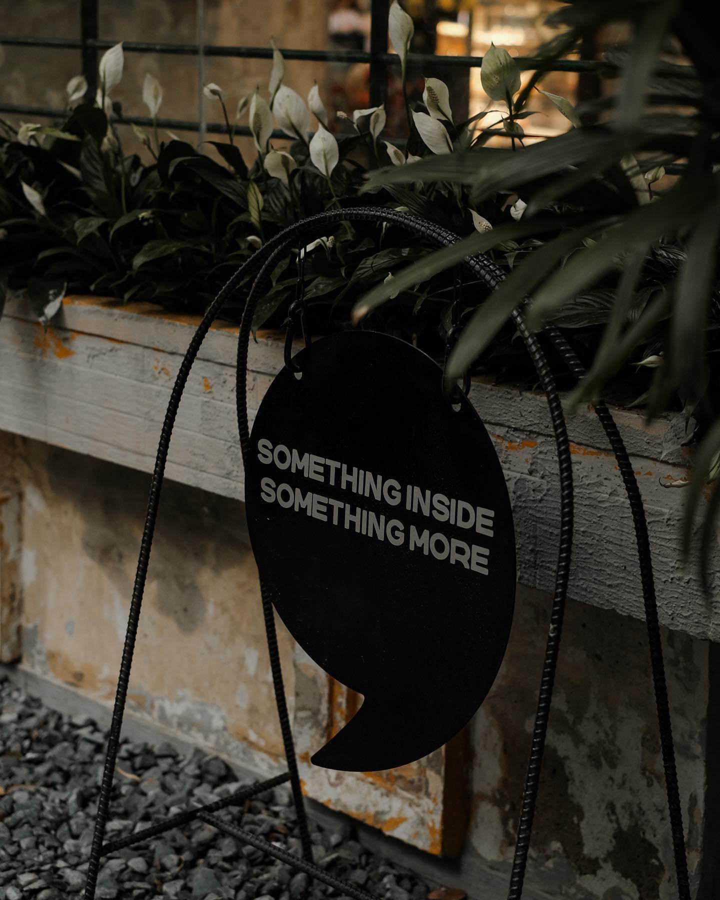 S'mores Saigon — the SOMETHING INSIDE SOMETHING MORE sign among plants