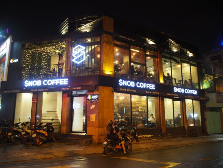 Snob Coffee facade at night with the blue neon sign