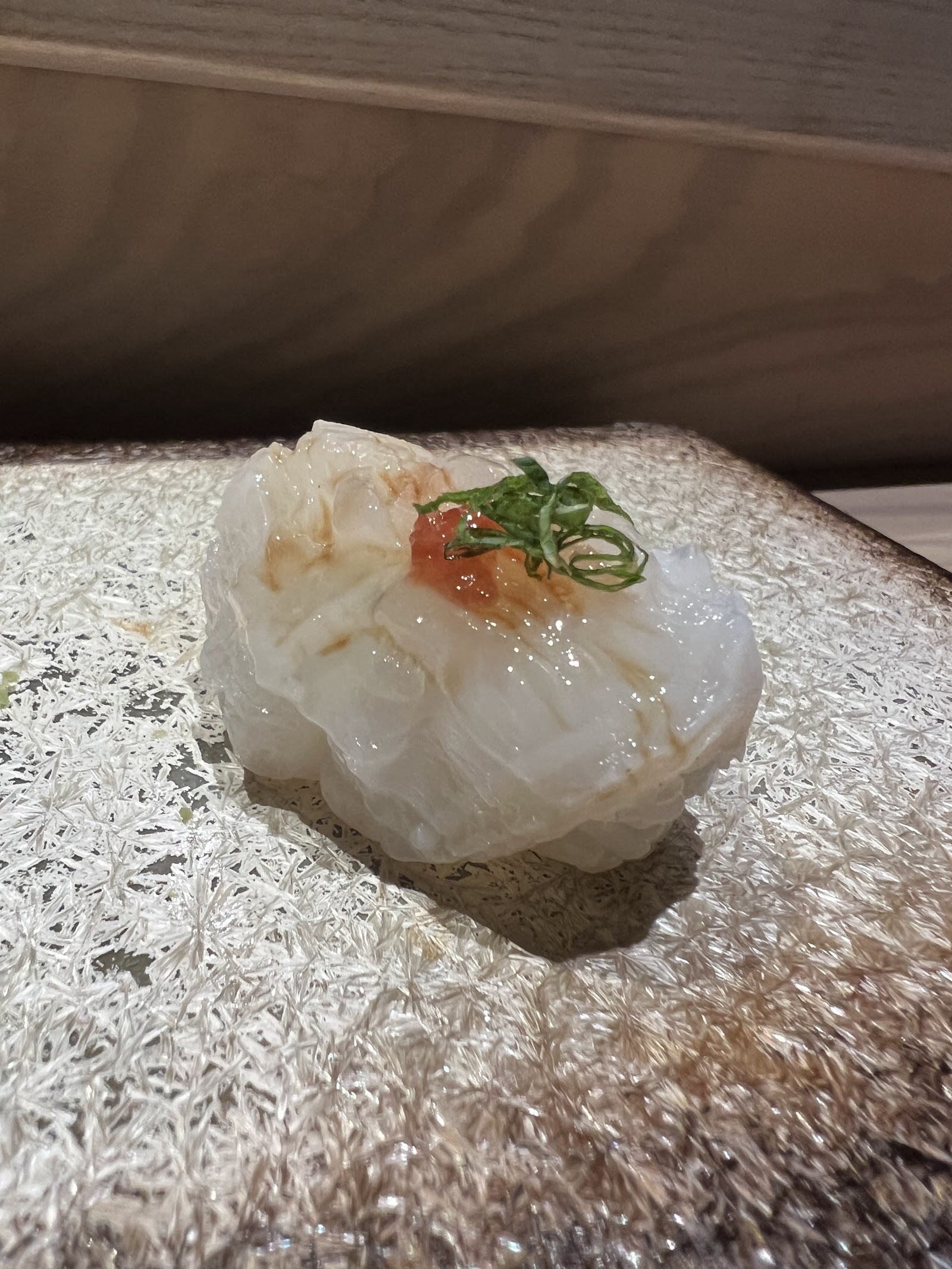 White-fish nigiri with scallion on a white stone plate