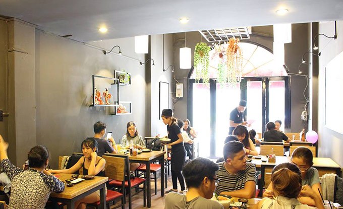 The warm dining hall with diners and staff
