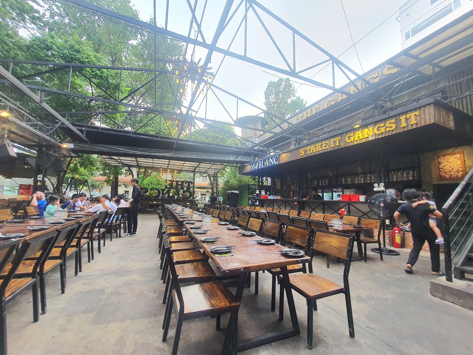 Khu vườn ngoài trời của The Gangs với bàn gỗ dài