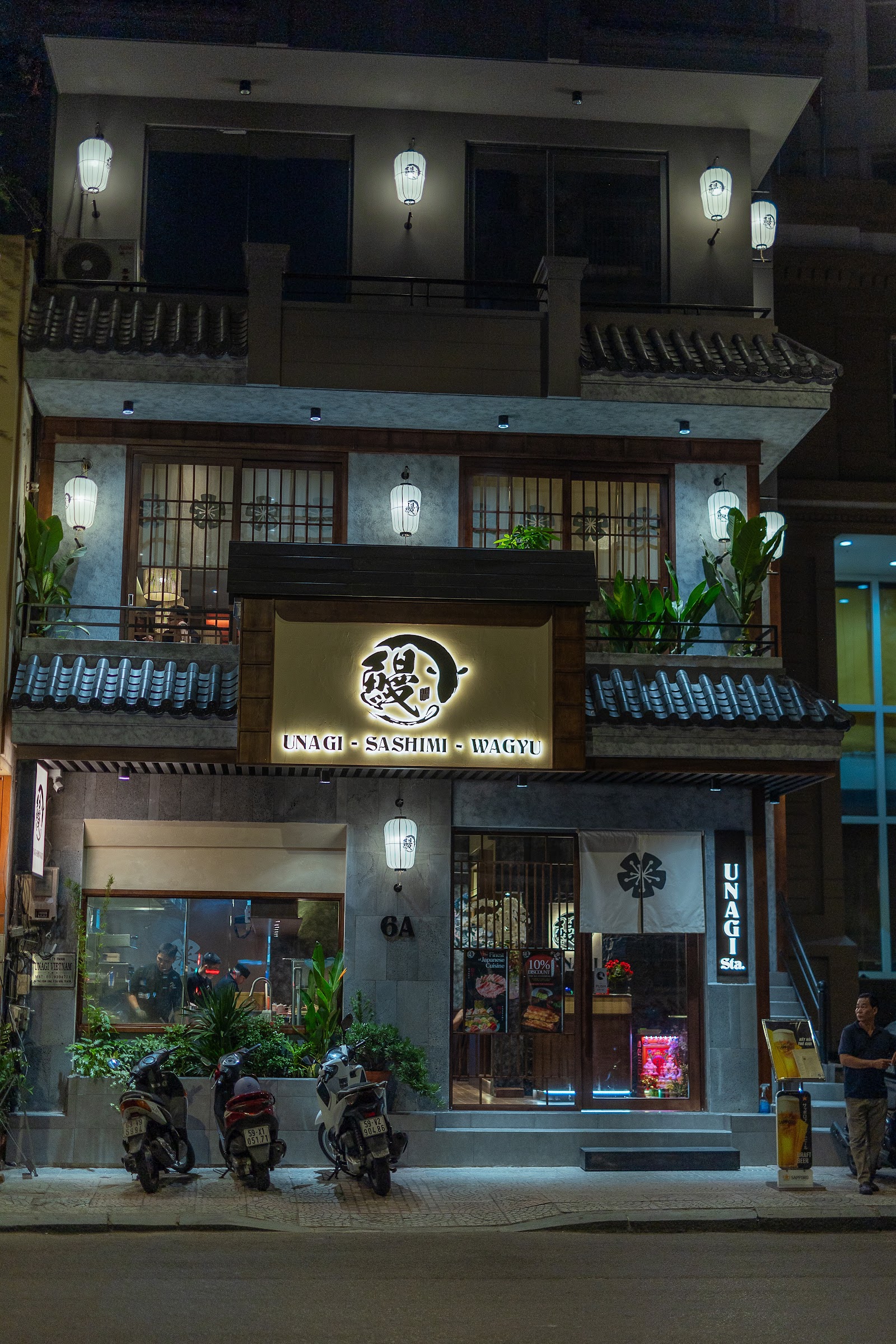 Mặt tiền Unagi Station về đêm, biển hiệu UNAGI – SASHIMI – WAGYU
